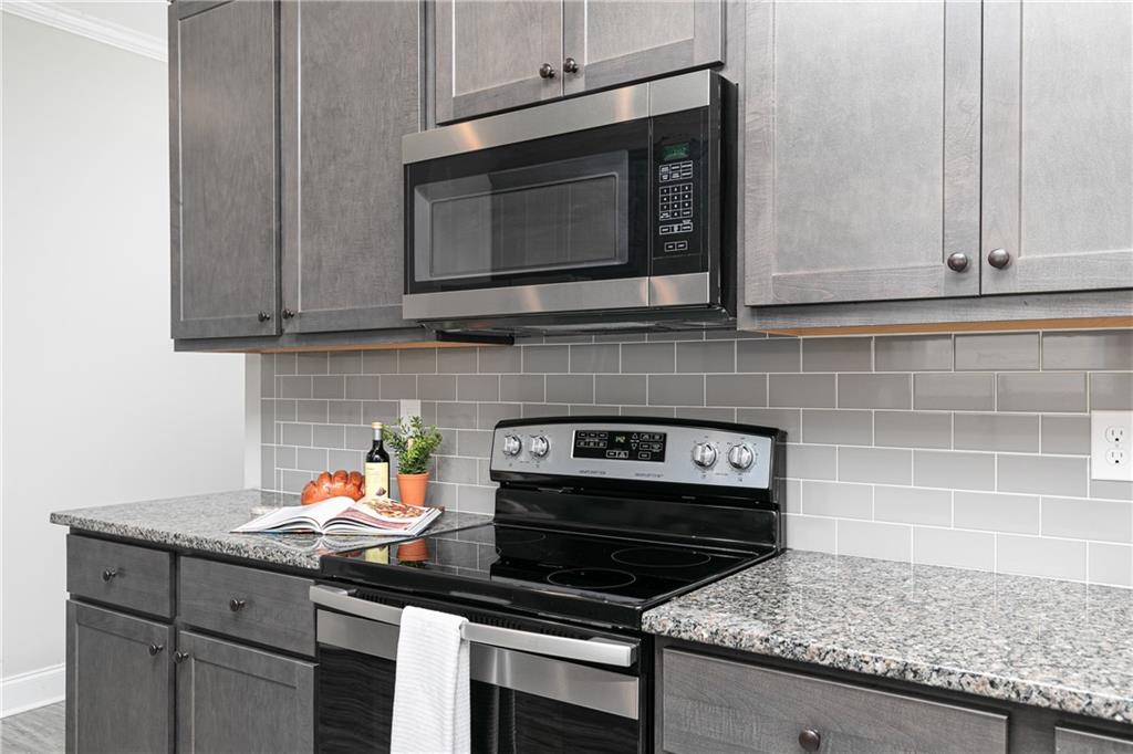 59 Calloway Lane Cartersville, GA 30120 - Photo 12 of 29 a kitchen with granite countertop a stove and a microwave