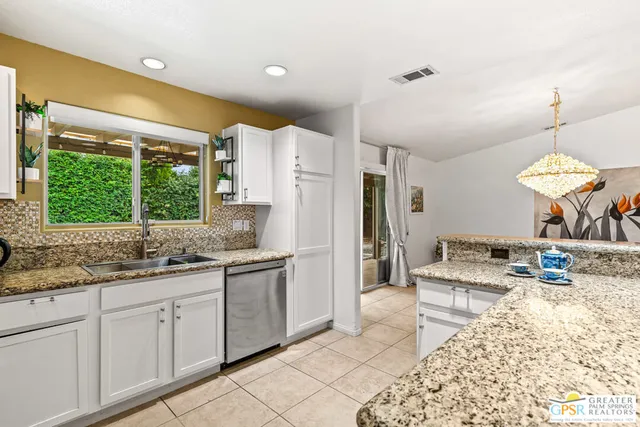 a kitchen with stainless steel appliances kitchen island granite countertop a refrigerator and a sink