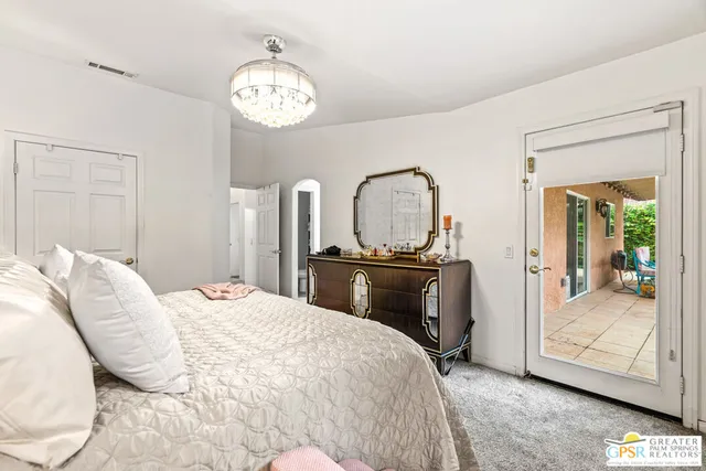 a bedroom with bed and a mirror