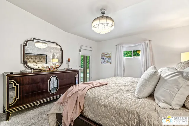a bedroom with a bed and a mirror on the dresser