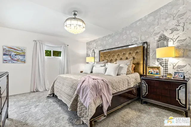 a spacious bedroom with a bed and a chandelier