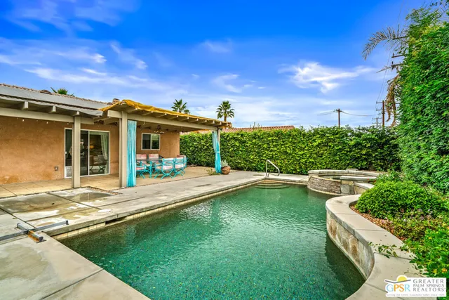 a view of a house with pool and chairs