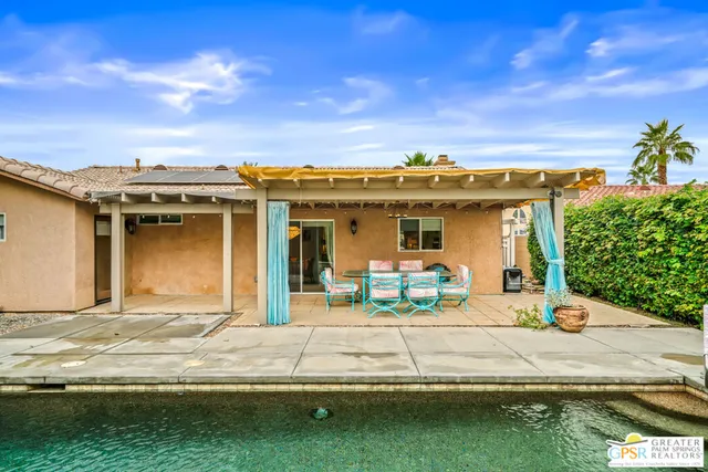 a view of a house with swimming pool and sitting area