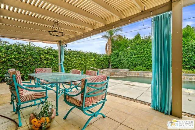 a patio with glass top table and chairs