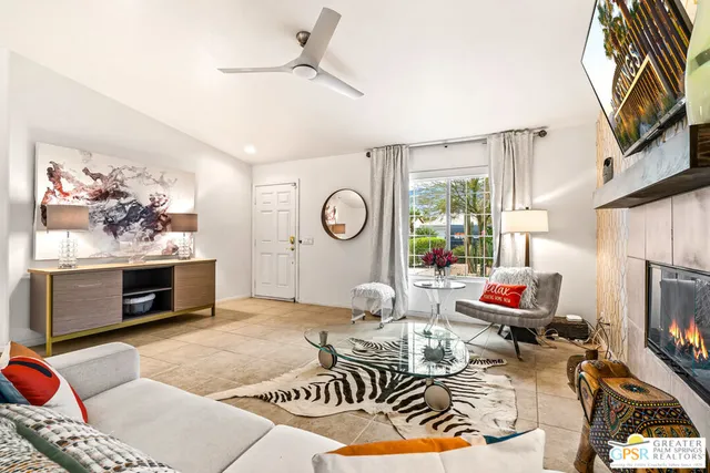 a living room with furniture a flat screen tv and a fireplace