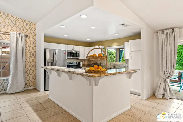a kitchen with stainless steel appliances granite countertop a refrigerator and a sink
