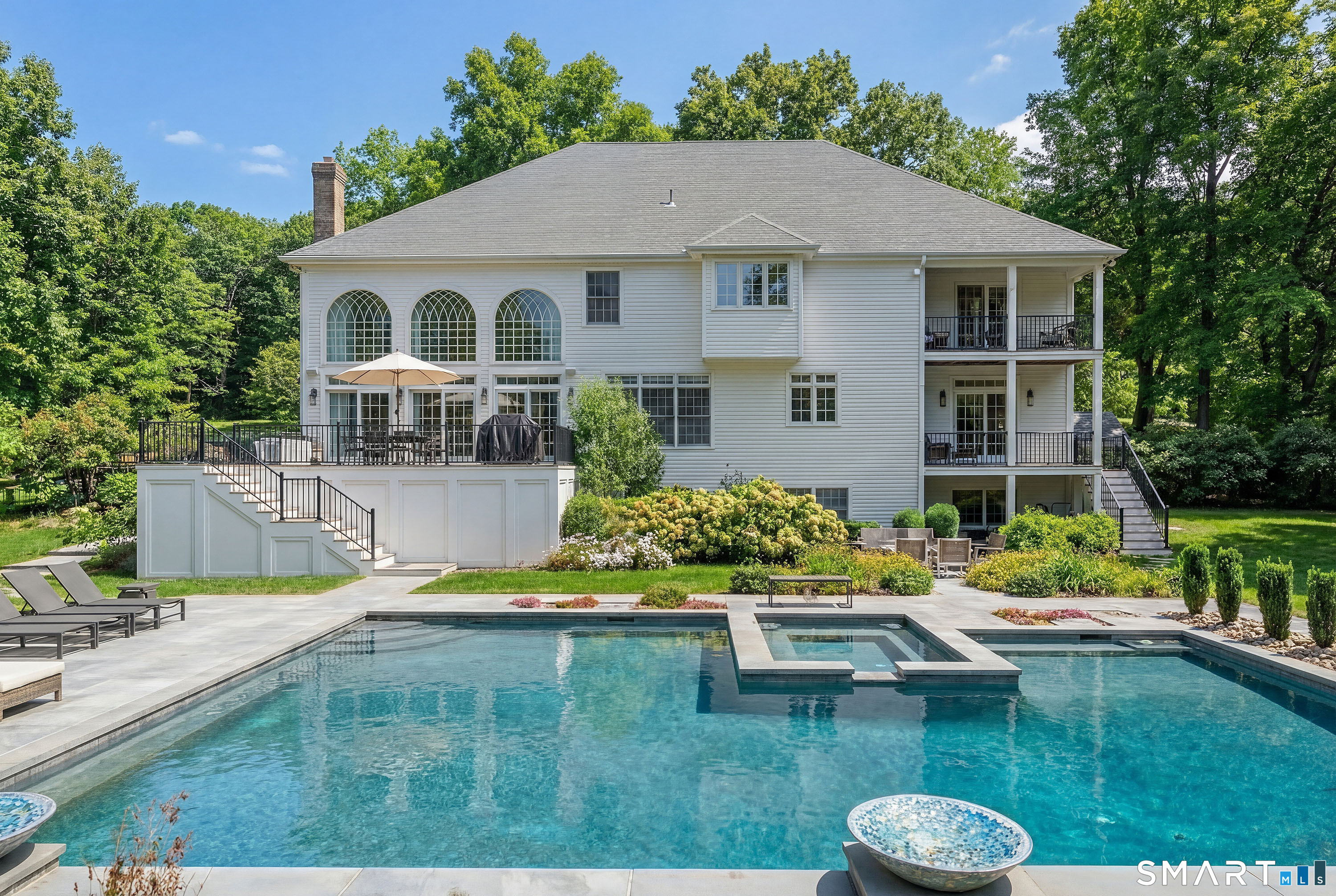 14 Merlins Lane Newtown, CT 06470 - Photo 32 of 40 Resort-style backyard featuring expansive patio, sparkling in-ground pool with spa, and multi-level deck overlooking lush grounds.