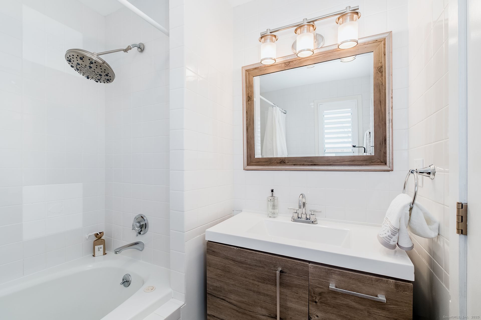 1987 Fairfield Beach Road Fairfield, CT 06824 - Photo 15 of 22 a bathroom with a sink vanity tub and a mirror