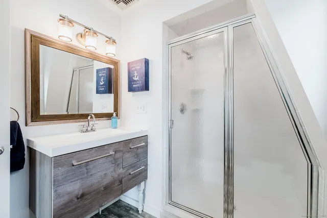 a bathroom with a sink vanity mirror and shower