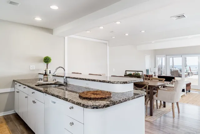 a kitchen with a sink a stove and chairs
