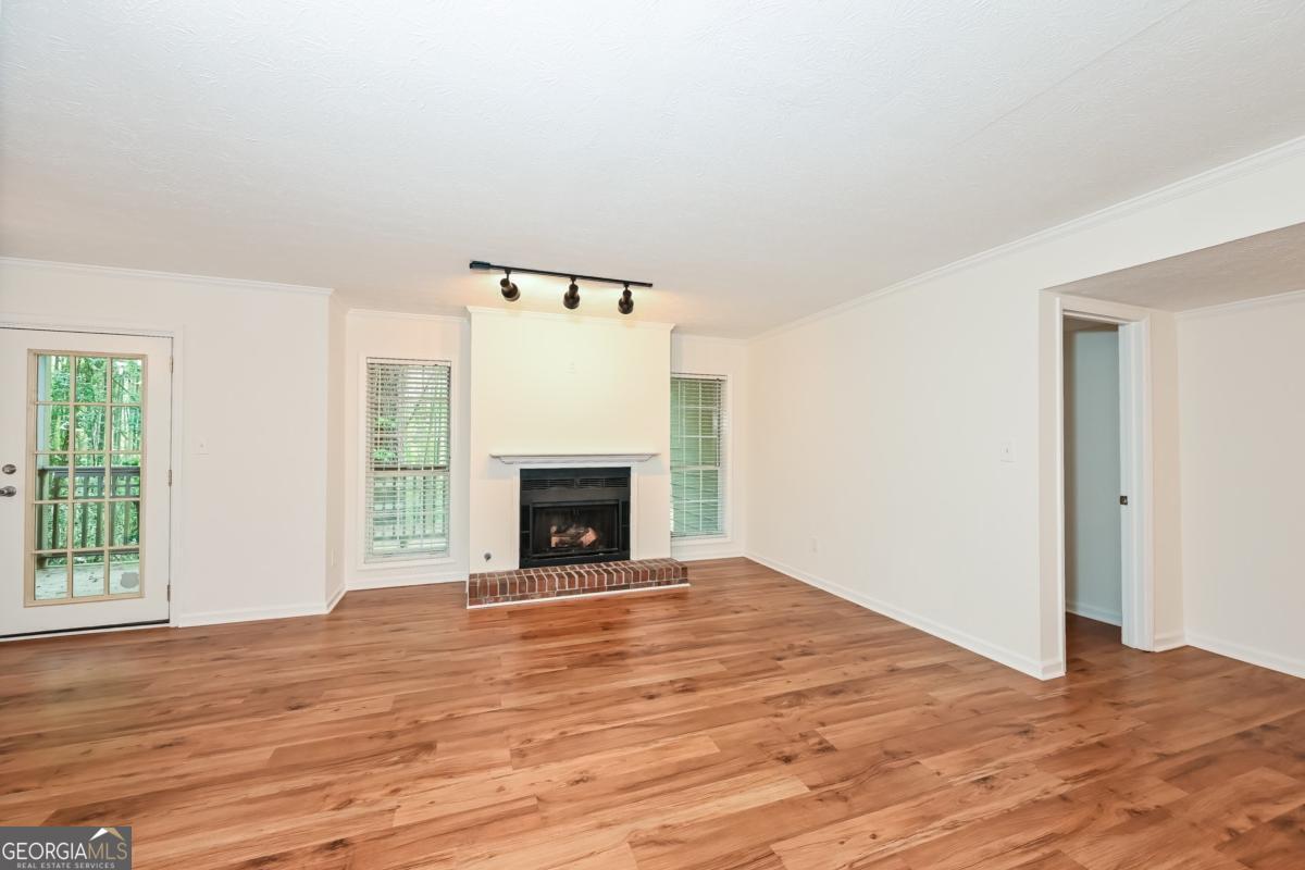 201 Lenox Way Northeast, Unit 201 Atlanta, GA 30324 - Photo 2 of 15 a view of empty room with wooden floor and fireplace