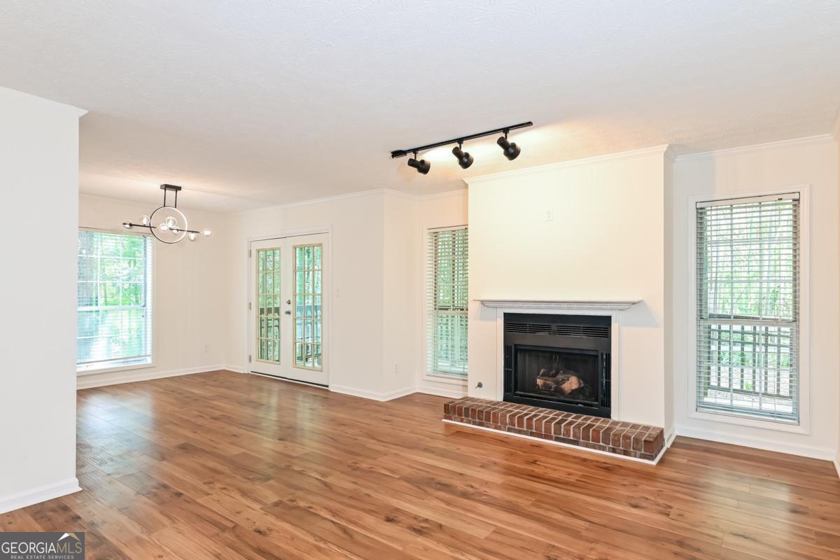 201 Lenox Way Northeast, Unit 201 Atlanta, GA 30324 - Photo 3 of 15 a view of an empty room with wooden floor fireplace and a window
