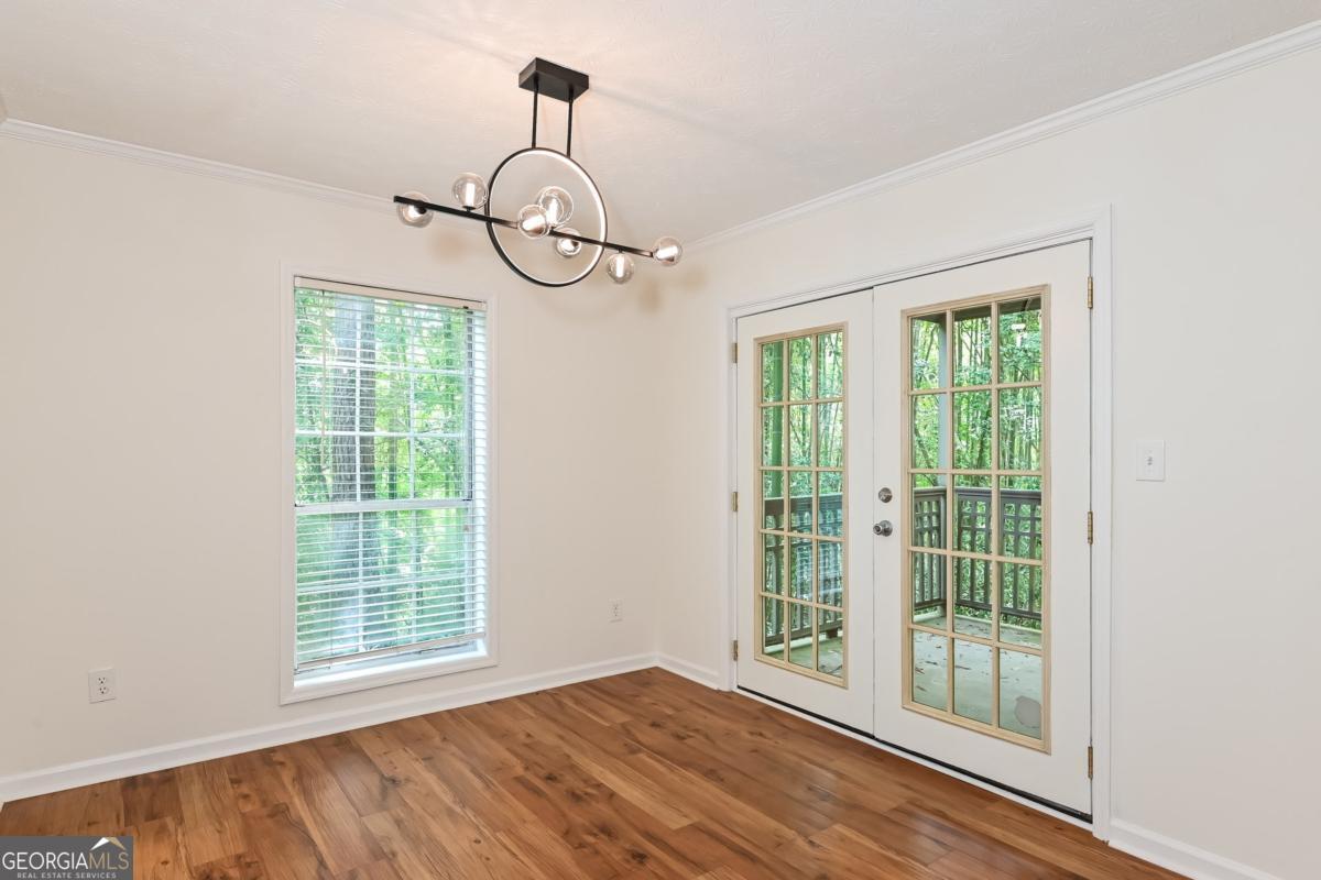 201 Lenox Way Northeast, Unit 201 Atlanta, GA 30324 - Photo 6 of 15 a view of empty room with windows and wooden floor