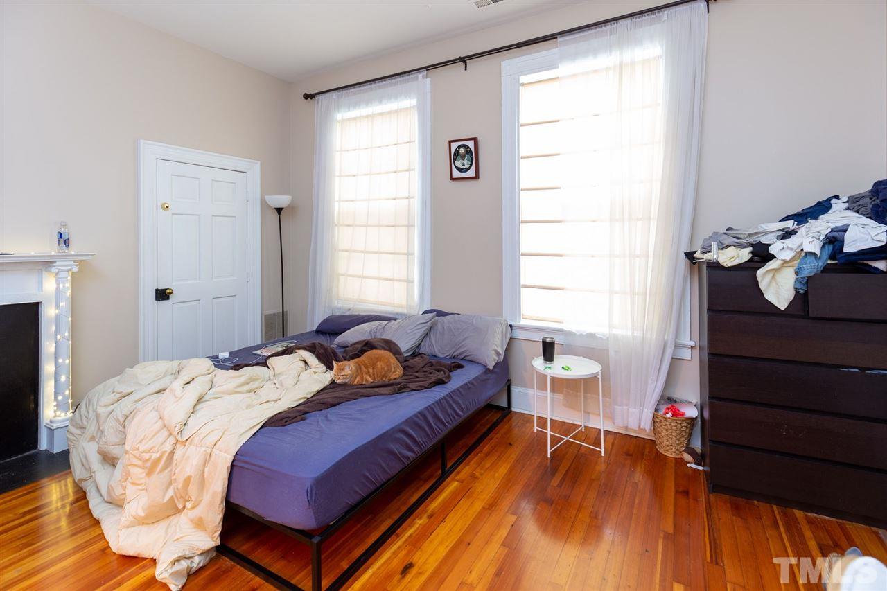 112 Forest Road Raleigh, NC 27605 - Photo 10 of 14 a bedroom with a bed and wooden floor