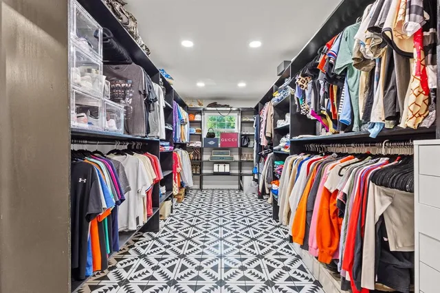 a view of walk in closet with clothes and shoes