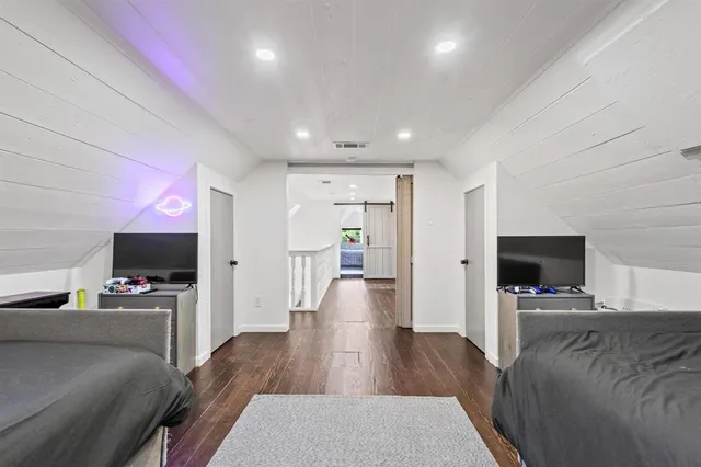 a view of a livingroom with a flat screen tv wooden floor and a fireplace