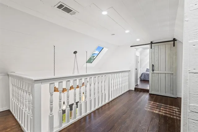 a view of hallway with wooden floor and stairs