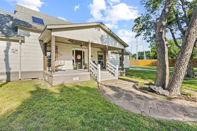 a view of a house with backyard and a tree
