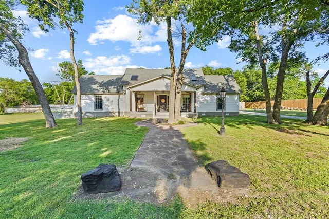 a view of a house with garden and a tree
