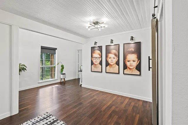 a view of an empty room with window wooden floor and a ceiling fan