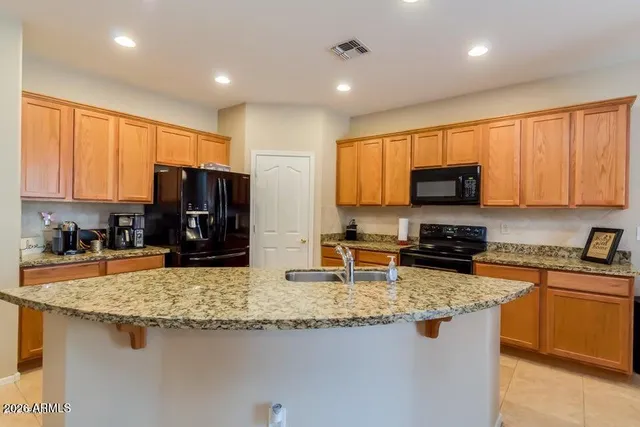 a kitchen with kitchen island granite countertop a sink stove and microwave