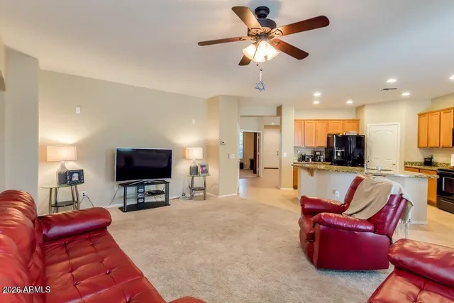 a living room with furniture a flat screen tv and kitchen view