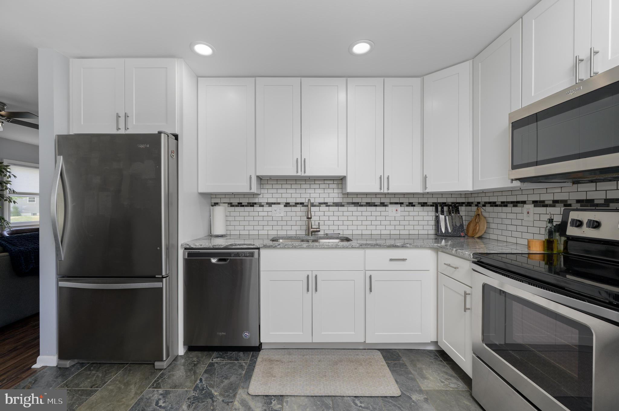500 Jackson Avenue Magnolia, NJ 08049 - Photo 8 of 21 a kitchen with stainless steel appliances granite countertop a refrigerator stove a sink and dishwasher with white cabinets