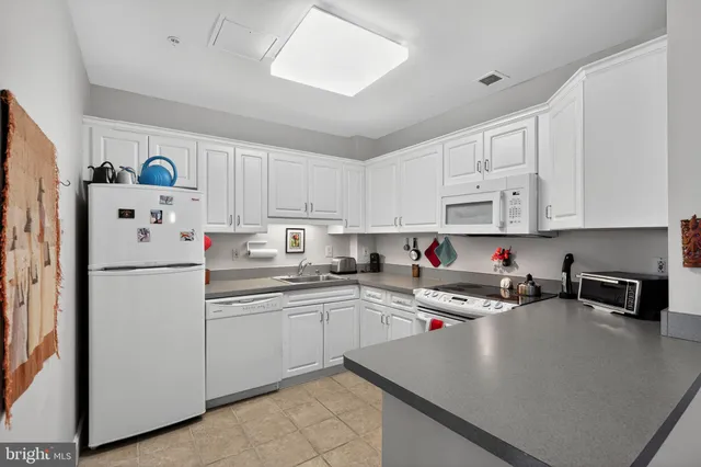 a kitchen with white cabinets and white appliances