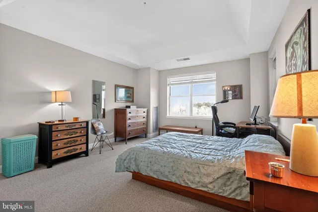 a bedroom with a bed and dresser with mirror