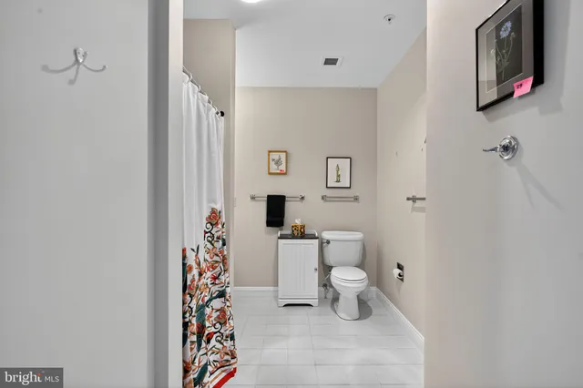 a bathroom with a toilet and a shower curtain