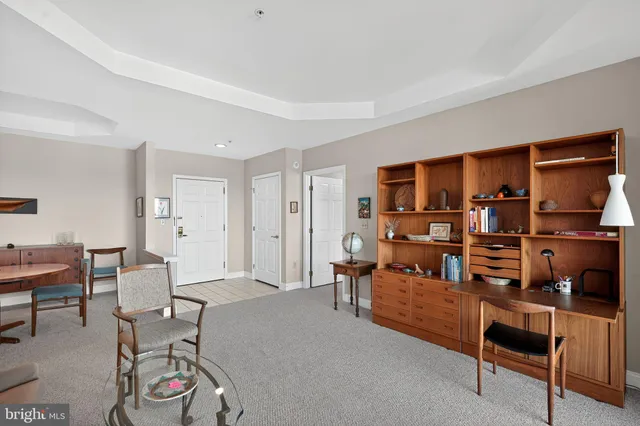 a living room with furniture a rug and a bookshelf