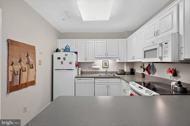 a kitchen with white cabinets and white appliances