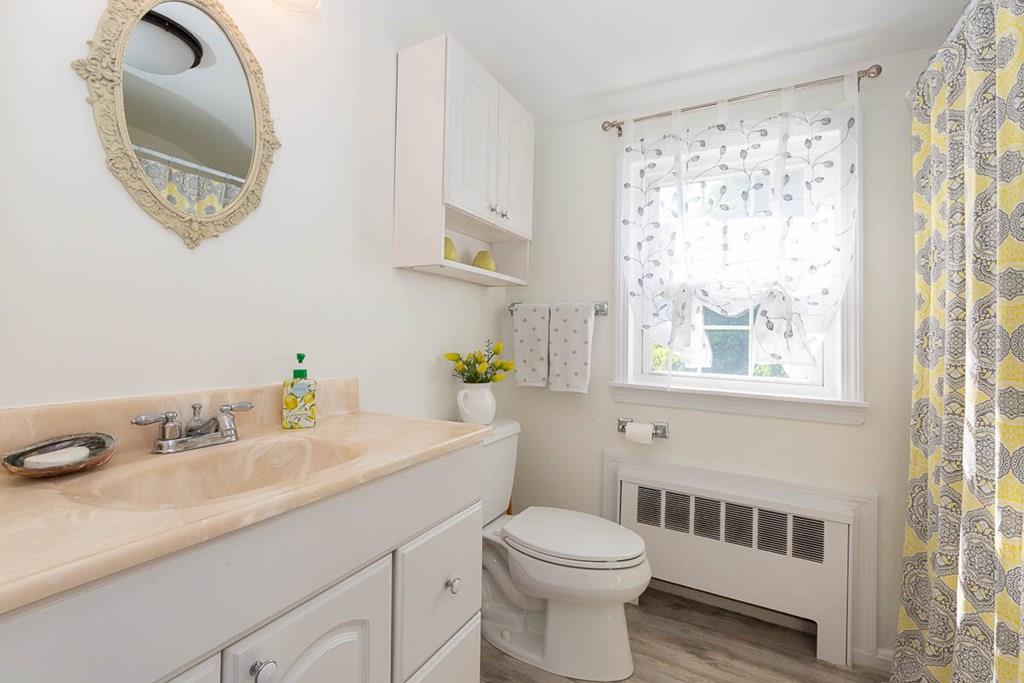 10 Ross Road Lexington, MA 02421 - Photo 28 of 36 a bathroom with a sink a mirror and a window