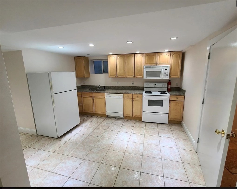 1 Hilltop Road, Unit B Watertown, MA 02472 - Photo 2 of 5 a kitchen with stainless steel appliances granite countertop a stove a sink and a refrigerator