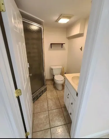 a bathroom with a granite countertop shower and a toilet