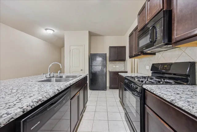 a kitchen with stainless steel appliances granite countertop a stove sink and cabinets