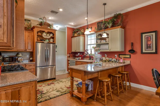 a kitchen with stainless steel appliances granite countertop a sink a microwave cabinets and a dining table