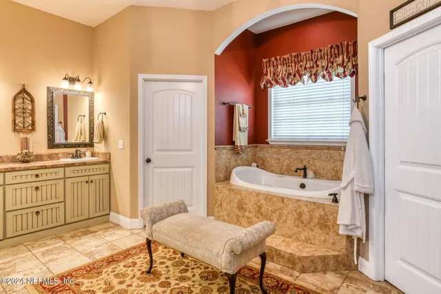 a spacious bathroom with a mirror a sink and a shower