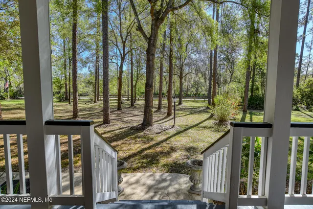 a view of a brick house with large windows and a table and chairs