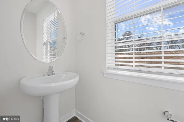 a bathroom with a sink a mirror and a window