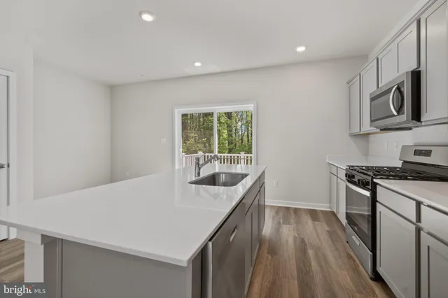 a kitchen with stainless steel appliances granite countertop a stove a sink and a refrigerator