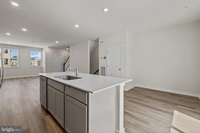a kitchen with a sink and wooden floor