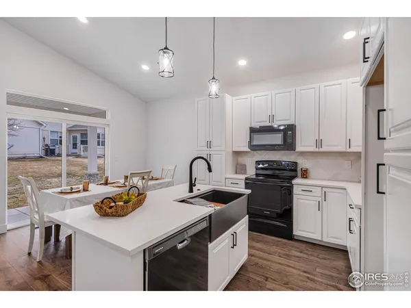 a kitchen with kitchen island granite countertop a sink cabinets and stainless steel appliances
