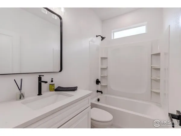 a bathroom with a bathtub sink vanity and mirror