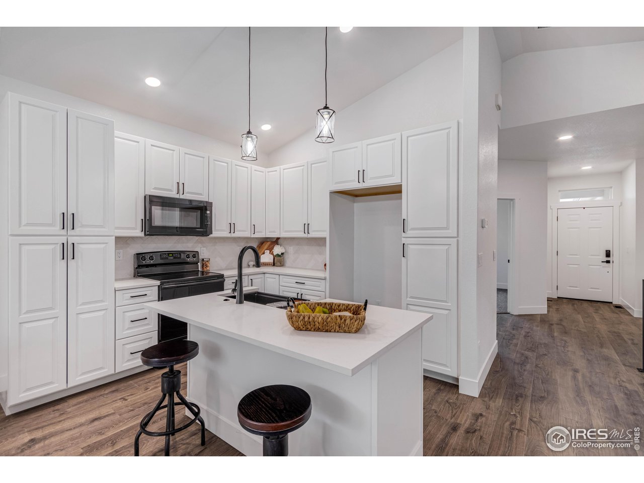 1230 Swainson Road Eaton, CO 80615 - Photo 9 of 29 a kitchen with stainless steel appliances granite countertop a sink a stove a refrigerator cabinets and a dining table