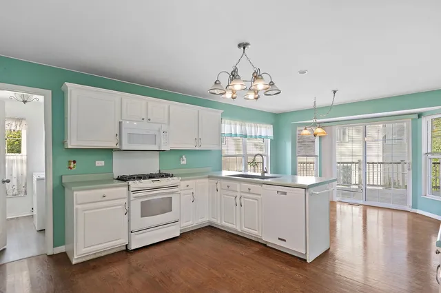 a kitchen with stainless steel appliances a white stove top oven and a wooden floors
