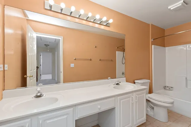 a bathroom with a sink double vanity and a toilet