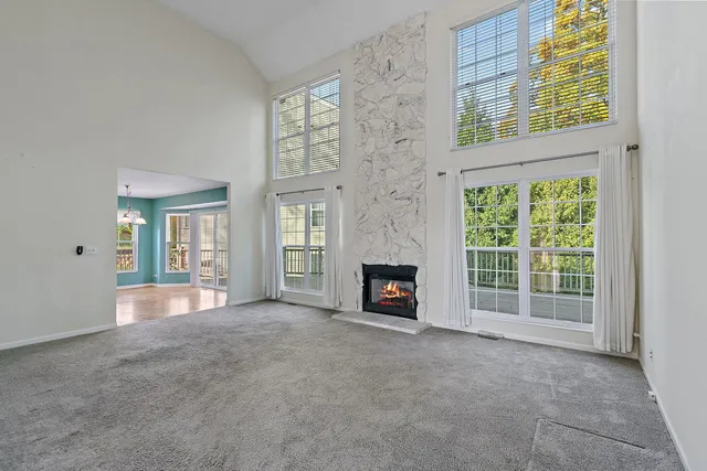 an empty room with windows and fireplace