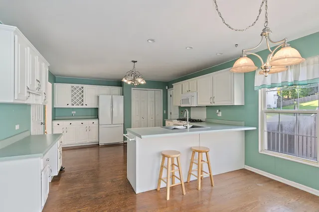 a large kitchen with kitchen island a island a sink a stove and a refrigerator