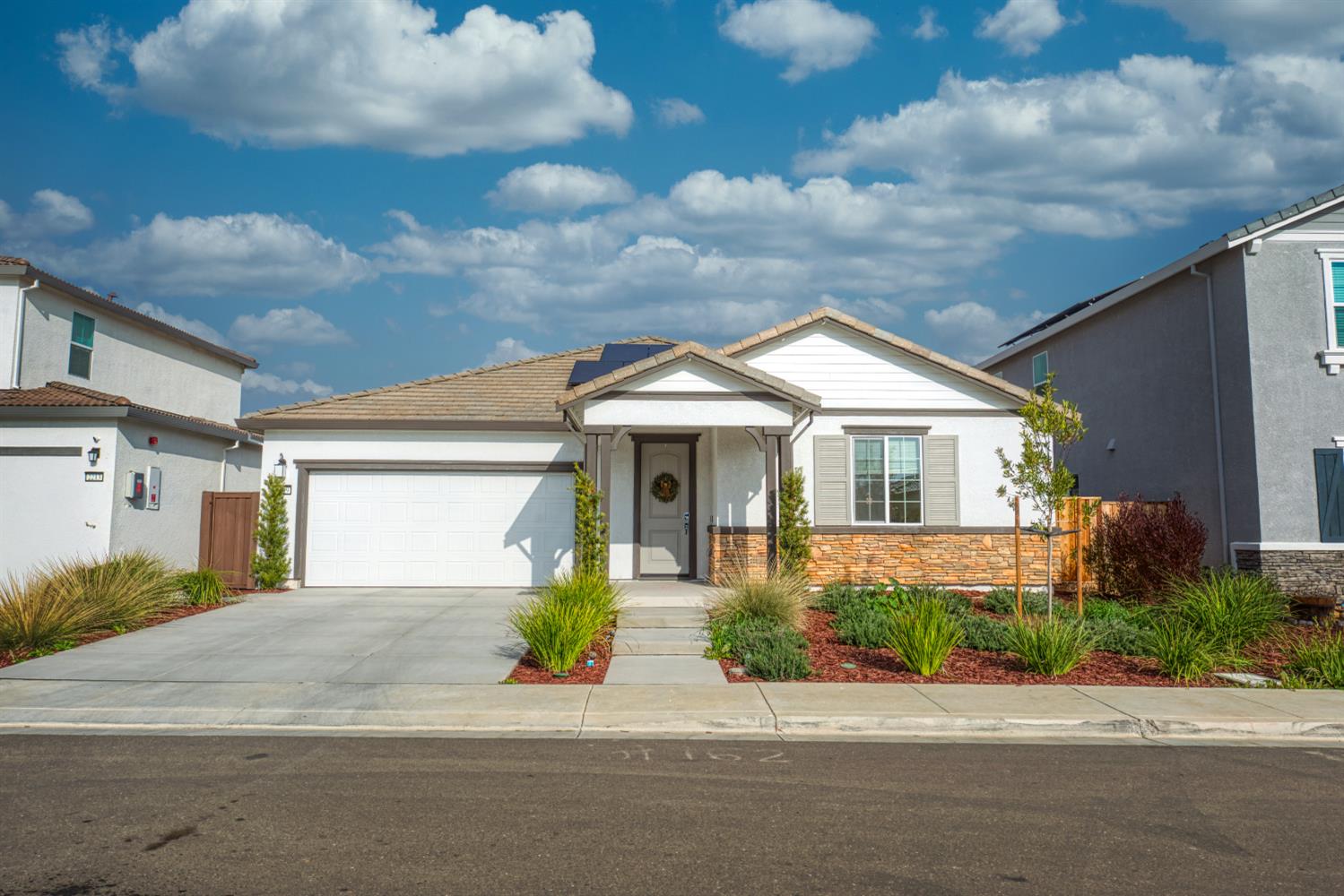 a front view of a house with a garden and plants